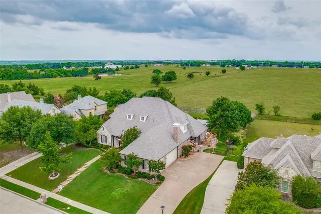 an aerial view of a house with garden space and ocean view
