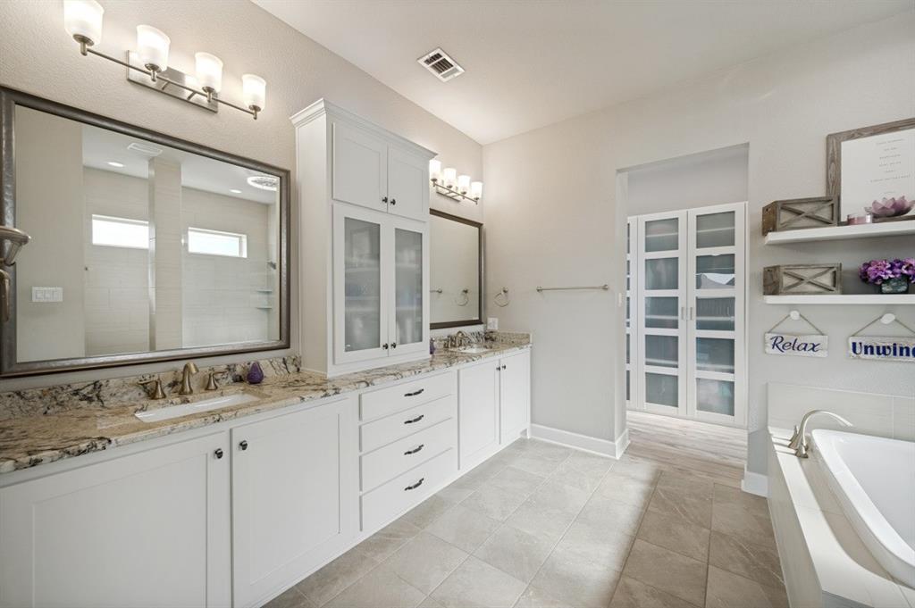 2721 Old Shire Path Road Prosper, TX 75078 - Photo 10 of 39 Spacious primary bathroom featuring dual white vanities with granite countertops, and extensive cabinet storage