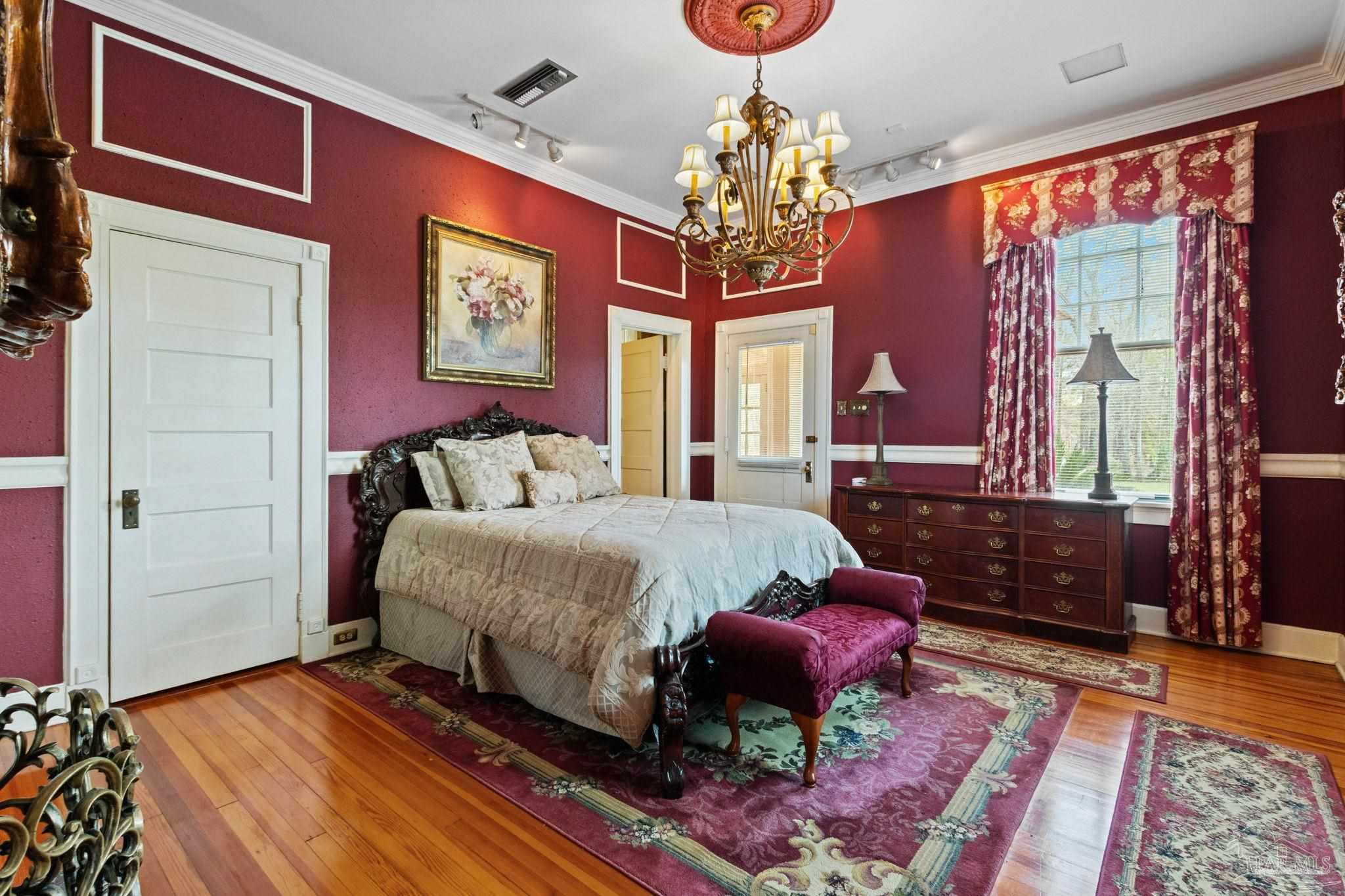 1701 Sowell Road Brewton, AL 36426 - Photo 54 of 72 a spacious bedroom with a bed and a chandelier