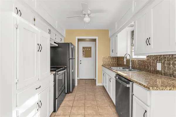 a kitchen with granite countertop a sink stove and refrigerator