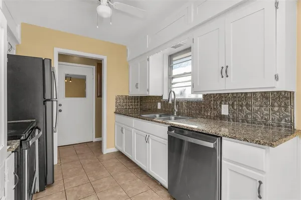 a kitchen with granite countertop a sink stainless steel appliances and cabinets