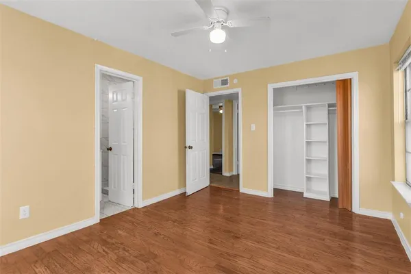 a view of empty room with wooden floor