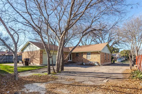 a view of a house with a yard and large tree