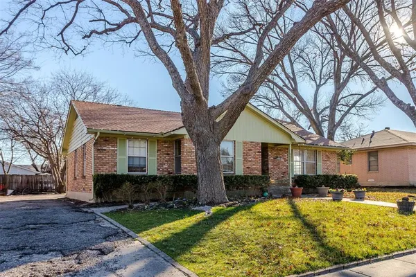 a view of a house with large trees and a yard
