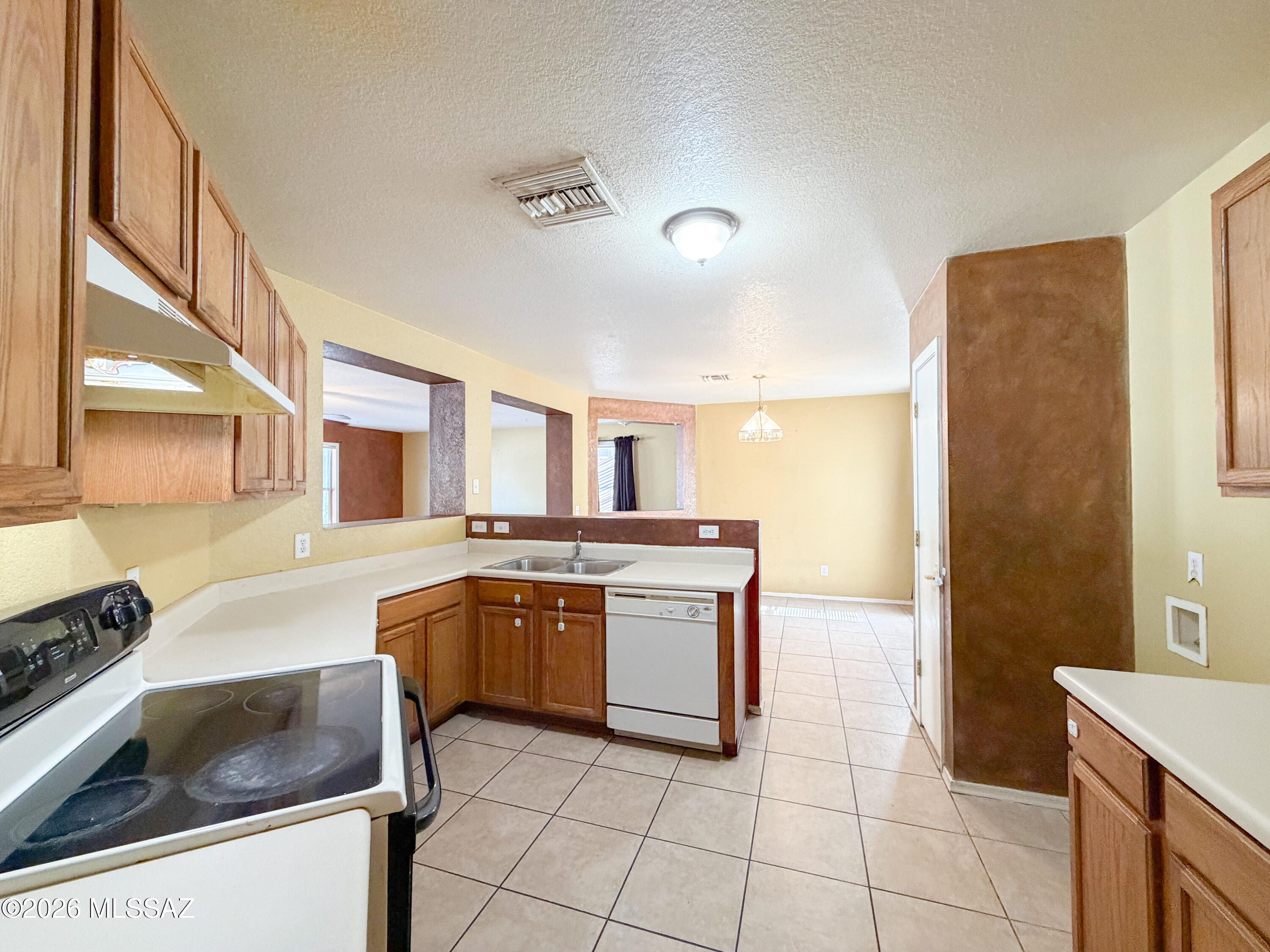 5779 South Manta Ray Road Tucson, AZ 85706 - Photo 6 of 30 a kitchen with a stove sink and cabinets