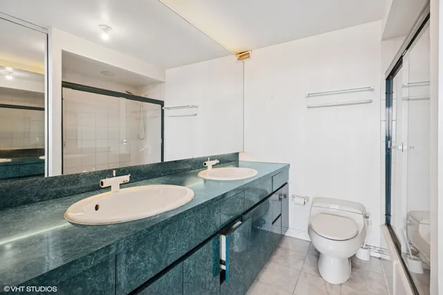 a bathroom with a granite countertop sink toilet a mirror and shower