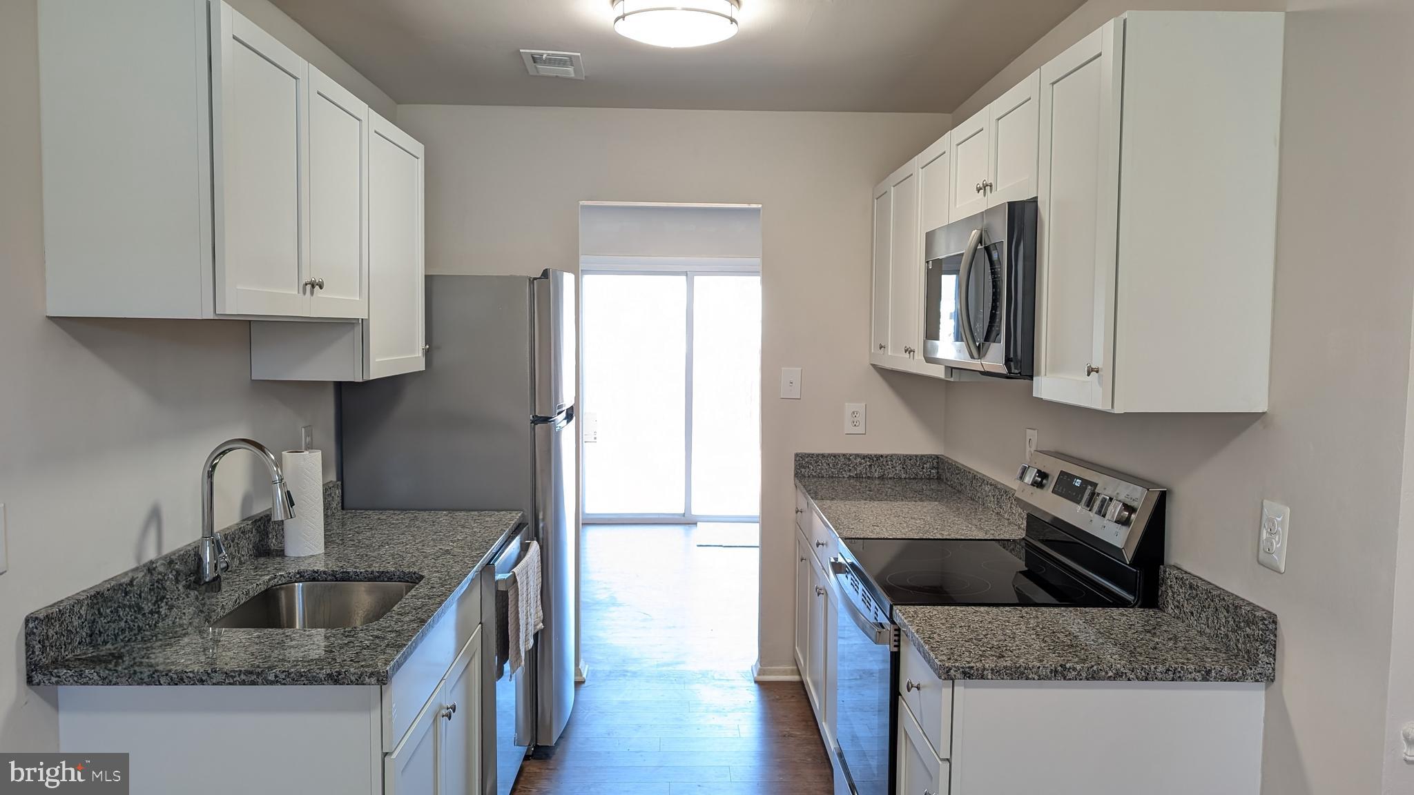 43 Vienna Court Frederick, MD 21702 - Photo 8 of 38 a kitchen with granite countertop a sink a stove and refrigerator