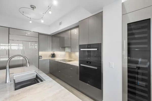 a dining room with furniture a floor to ceiling window and kitchen view