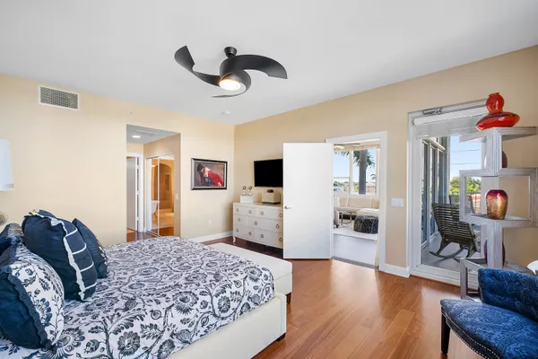 a large bedroom with a bed and wooden floor