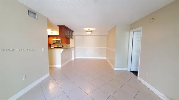 a view of a refrigerator in kitchen and a window