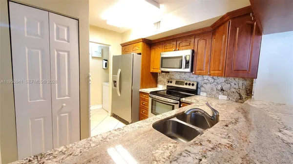 a kitchen with a stove a refrigerator and a sink