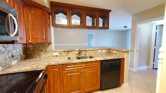 a kitchen with granite countertop a sink and a stove