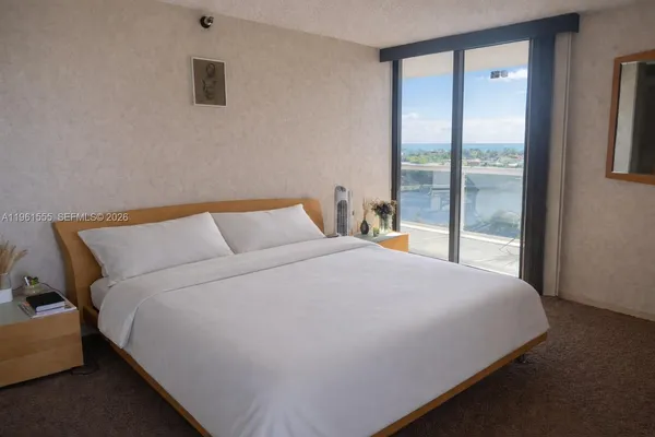 a large bed sitting in a bedroom next to a window