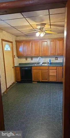 a room with granite countertop lots of wooden cabinets a sink and dishwasher