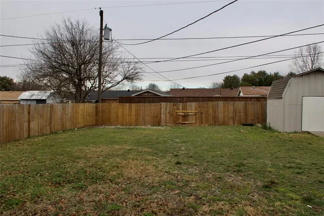 a view of a backyard with wooden fence