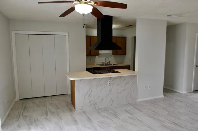 a living room with wooden floor and a ceiling fan
