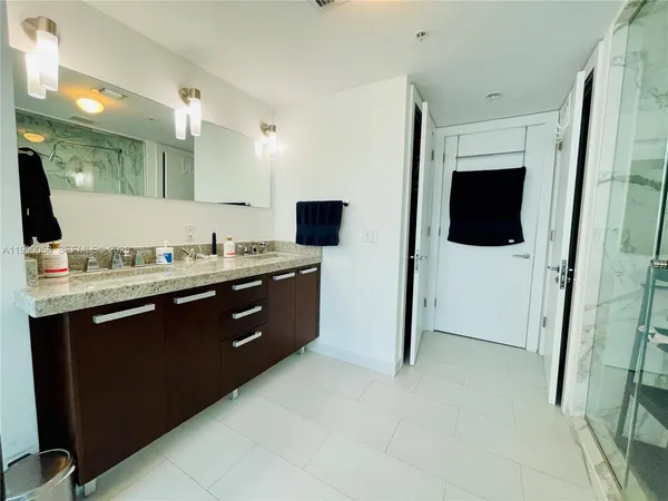 a spacious bathroom with a double vanity sink and a mirror