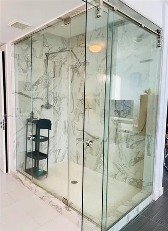 a bathroom with a glass shower door and a mirror