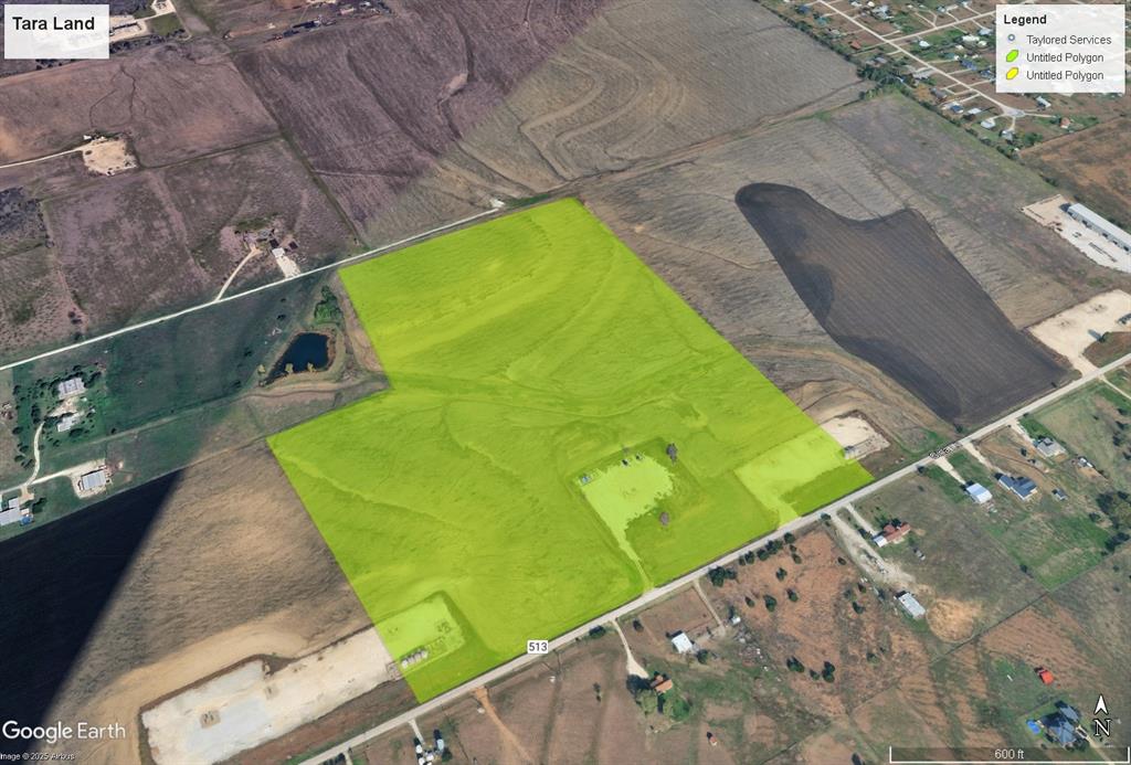 a green field with lots of trees in the background