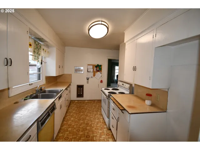 a kitchen with a sink refrigerator and cabinets