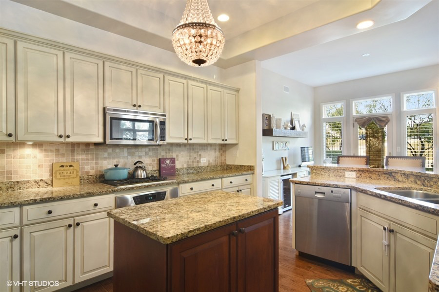 1532 West Rue James Place Palatine, IL 60067 - Photo 3 of 16 a kitchen with a sink a stove a microwave a center island and cabinets