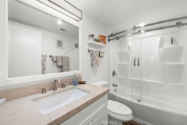 a bathroom with a granite countertop sink toilet tub and shower