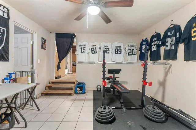 a room with gym equipment and wooden floor
