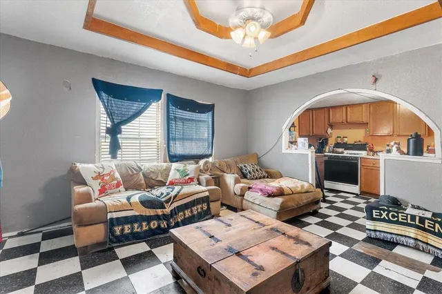a living room with furniture a rug and a dining table