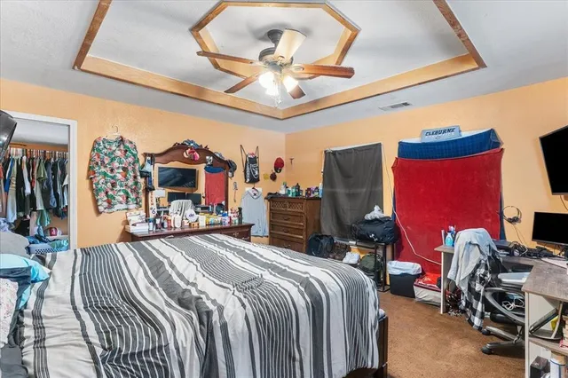 a bedroom with a bed a dresser and flat screen tv