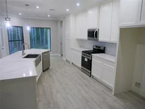 a kitchen with stainless steel appliances granite countertop a sink stove and refrigerator