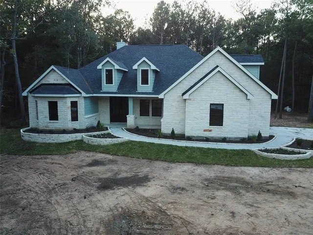 a view of a yard in front of a house with large trees