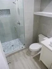 a white toilet sitting next to a shower