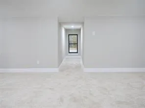 a view of an empty room with closet and mirror