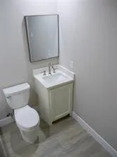 a bathroom with a toilet sink and mirror