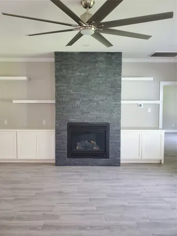 a view of a livingroom with a fireplace and a ceiling fan