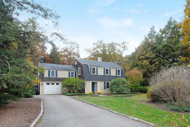 a front view of a house with a yard and trees