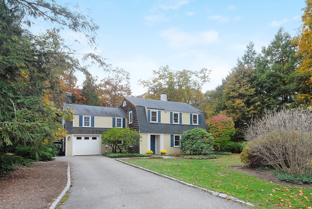 a front view of a house with a yard and trees
