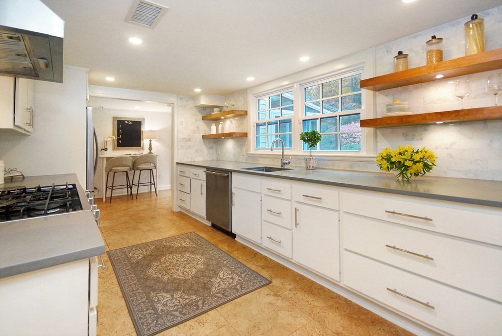 213 Nashoba Road Concord, MA 01742 - Photo 12 of 33 a kitchen with stainless steel appliances granite countertop a sink stove and cabinets