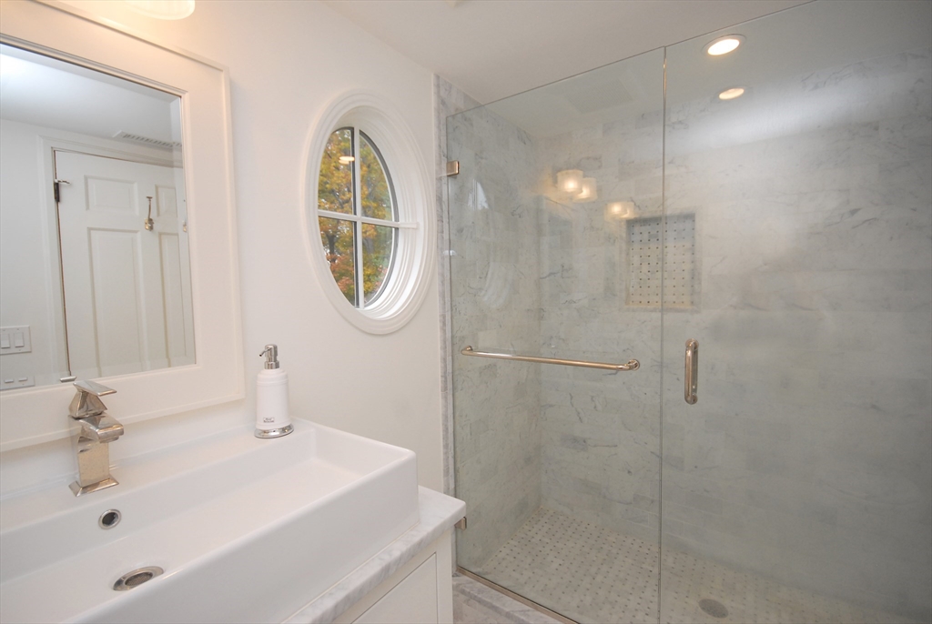 213 Nashoba Road Concord, MA 01742 - Photo 24 of 33 a bathroom with a sink a mirror and a shower