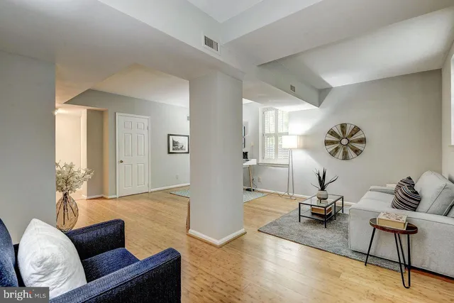 a living room with furniture and a wooden floor