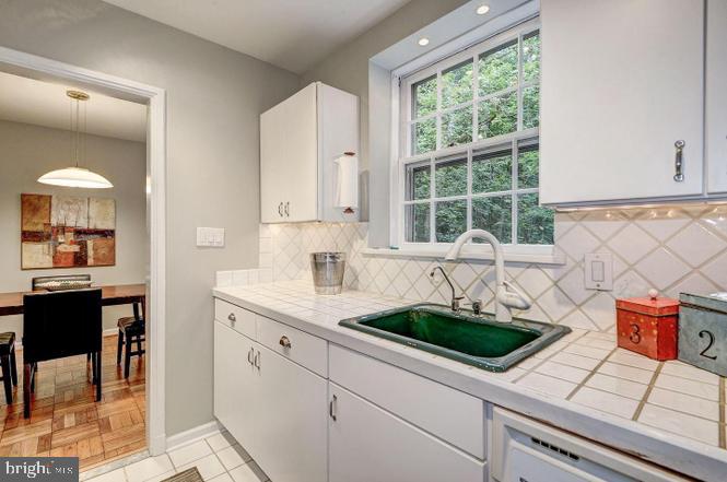 3500 39th Street Northwest, Unit B668 Washington, DC 20016 - Photo 25 of 30 a kitchen with stainless steel appliances a sink a stove and white cabinets next to a window