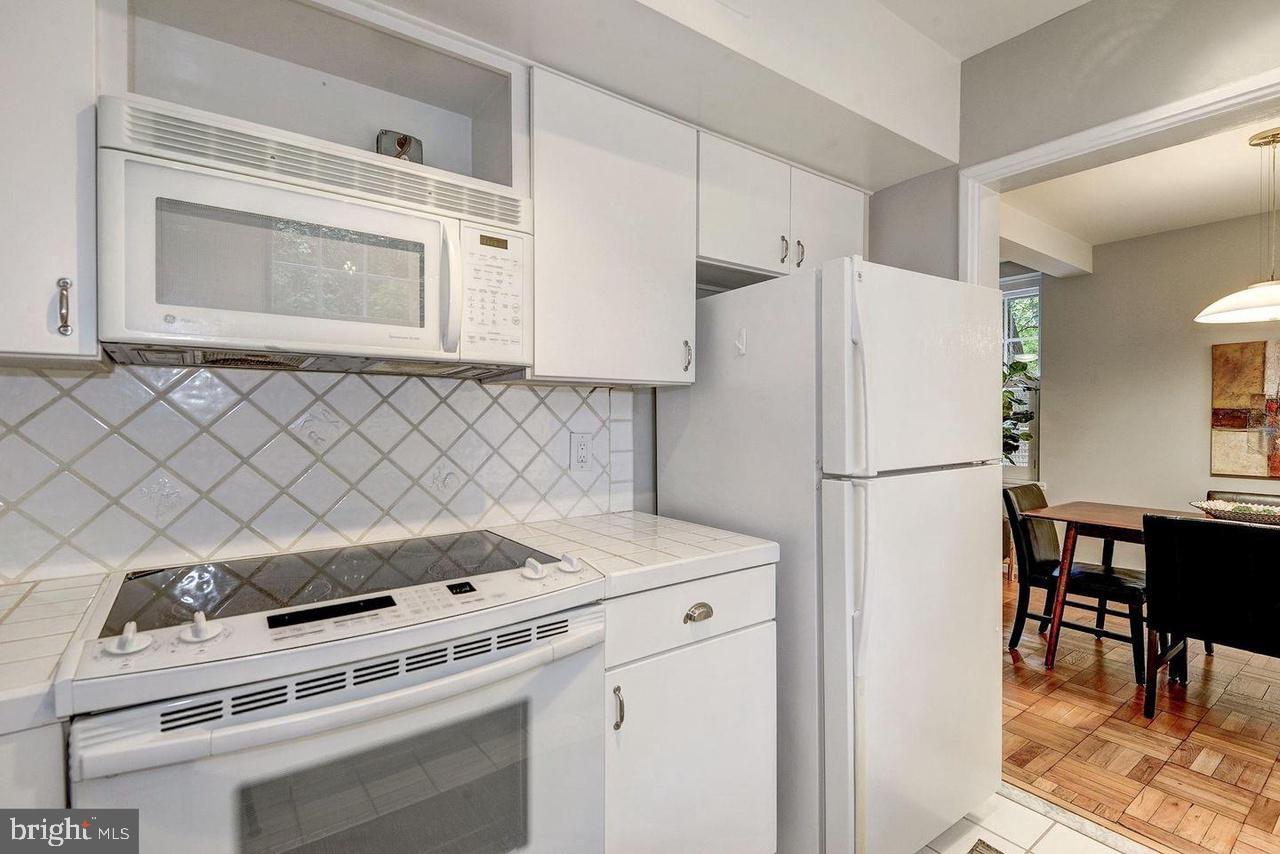 3500 39th Street Northwest, Unit B668 Washington, DC 20016 - Photo 26 of 30 a kitchen with a stove a refrigerator and a dining table