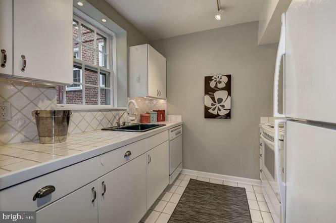 3500 39th Street Northwest, Unit B668 Washington, DC 20016 - Photo 27 of 30 a kitchen with stainless steel appliances granite countertop a sink and a granite counter tops with white cabinets