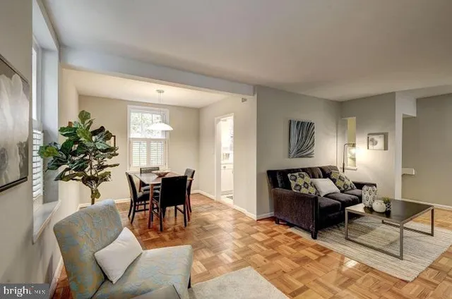 a dining room with furniture potted plants and wooden floor