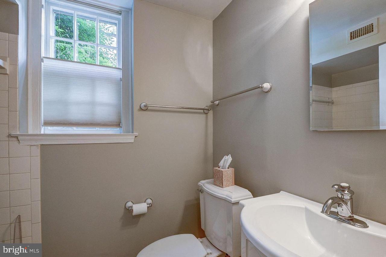 3500 39th Street Northwest, Unit B668 Washington, DC 20016 - Photo 10 of 30 a bathroom with a toilet a sink and mirror