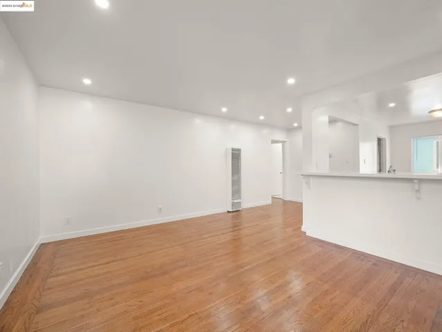 a view of an empty room with kitchen stove and refrigerator
