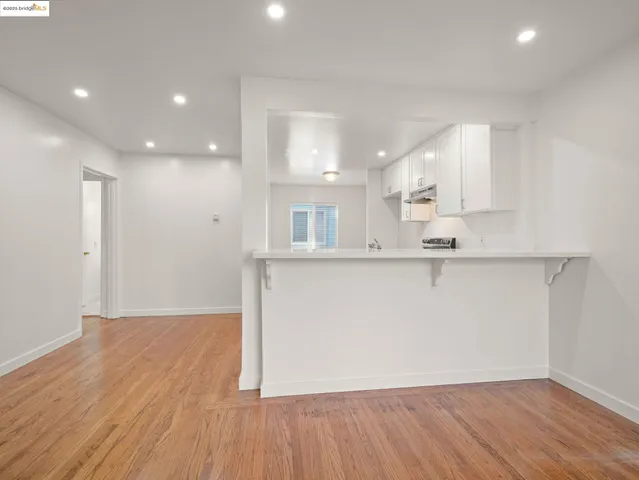 a view of a kitchen with wooden floor and a window