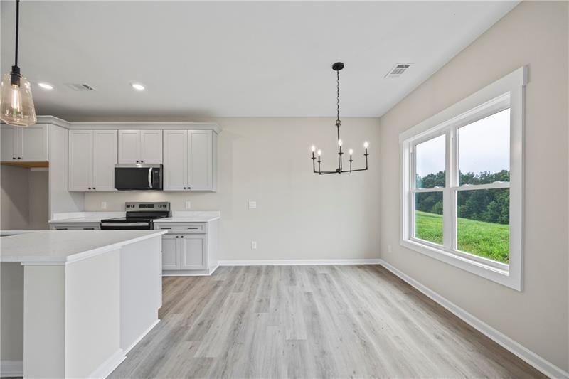 693 Racetrack Road Toccoa, GA 30577 - Photo 13 of 45 a kitchen with granite countertop stainless steel appliances a stove a sink a center island and a window