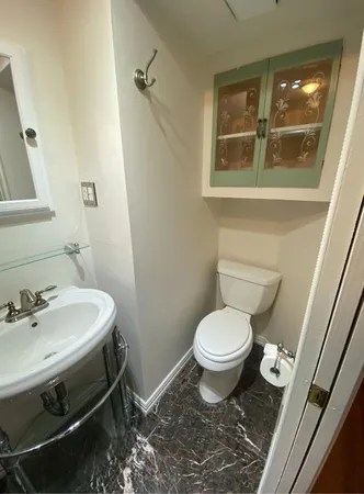 a bathroom with a sink toilet and a mirror