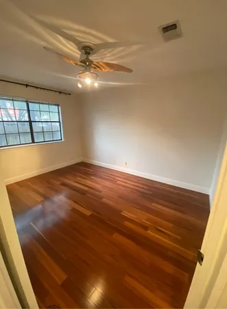a view of empty room with window and chandelier fan